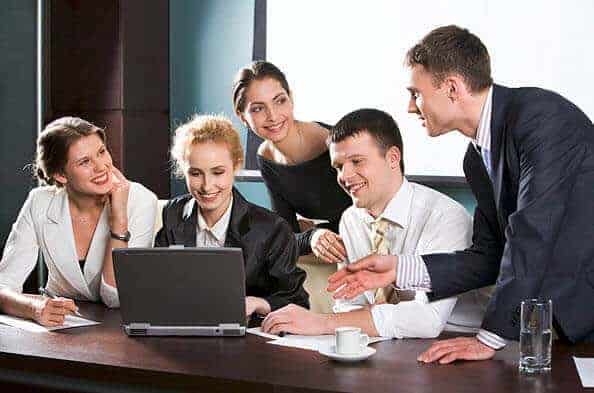expat group in the office look at the laptop screen